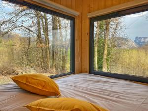 een bed met 2 kussens in een kamer met 2 ramen bij Le Perchoir du Vercors - Panorama sur les Cimes in Saint-André-en-Royans