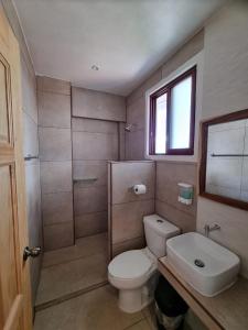 a bathroom with a toilet and a sink and a window at Posada Ziga Playa in Mazunte