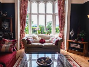 salon z kanapą i dużym oknem w obiekcie Lonsdale Villa Retreat w mieście Penrith