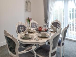 a dining room table with chairs and a table with wine glasses at Bracken Dene in Cresswell