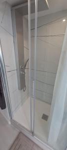 La salle de bains est pourvue d'une douche avec une porte en verre. dans l'établissement Port 1, à Tarragone