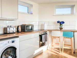 a kitchen with a washer and dryer on a counter at Keel Annexe in Week Saint Mary