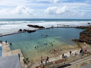 un grupo de personas en una piscina en la playa en Keel Annexe, en Week Saint Mary