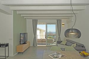 ein Wohnzimmer mit einem Sofa und einem TV in der Unterkunft La Cittadella P1-14 by Wonderful Italy in Manerba del Garda