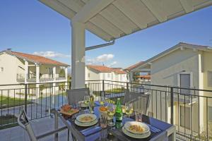 eine Terrasse mit einem Tisch und Stühlen auf dem Balkon in der Unterkunft La Cittadella P1-14 by Wonderful Italy in Manerba del Garda