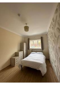 a bedroom with a white bed and a window at En-suites Rooms in Northampton in Moulton