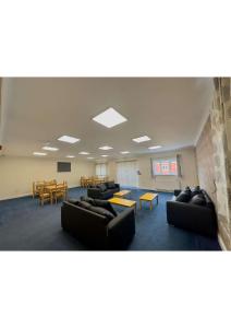 MoultonにあるEn-suites Rooms in Northamptonのソファとテーブル付きの広い部屋、教室が備わります。
