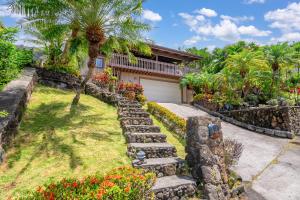 a house with a palm tree and a driveway at Seabreeze Hawaii Kai - 30-Night Minimum in Honolulu