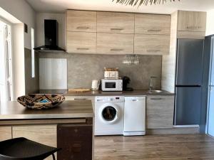 a kitchen with a washing machine and a microwave at Kasamia vue mer à St Leu in Saint-Leu