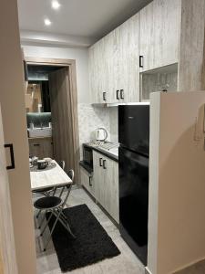 eine Küche mit einem schwarzen Kühlschrank und einem Tisch in der Unterkunft MSK Rotonda Studio 1 in Thessaloniki