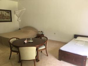Pokój z łóżkiem, stołem i krzesłami w obiekcie Raja Beach Hotel w mieście Balapitiya