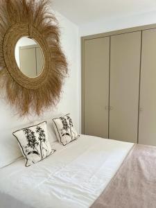 a bedroom with a bed with two pillows and a mirror at Moraira Fantástico Ático Duplex in Moraira