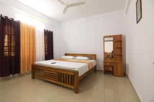 a bedroom with a bed and a mirror in it at THEKKADY HOMES in Thekkady