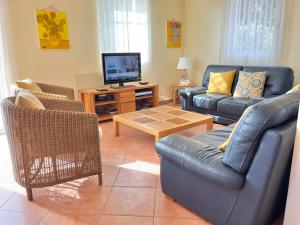 ein Wohnzimmer mit einem Sofa und einem TV in der Unterkunft Villa Romuald in Sainte-Maxime