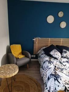 een slaapkamer met een bed, een stoel en een tafel bij Le Clos Duthu, Ideal curistes in Bagnères-de-Bigorre