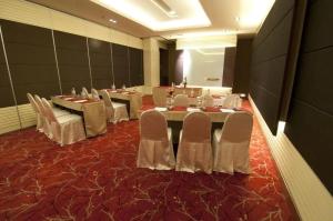 a conference room with tables and white chairs at Meta @ Swiss Garden Residence KL Bukit Bintang in Kuala Lumpur