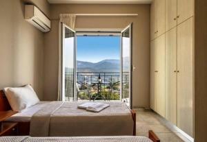 een slaapkamer met een bed en een groot raam bij Grand view resort in Argostoli