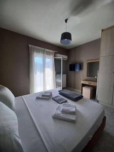 een slaapkamer met een groot wit bed en handdoeken bij Grand view resort in Argostoli