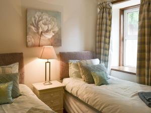 sypialnia z 2 łóżkami i oknem w obiekcie Nursery Cottage - Beaufort Estate w mieście Kiltarlty