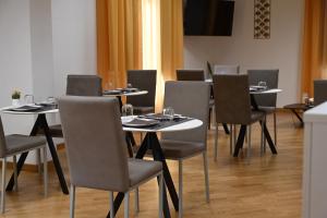 ein Esszimmer mit Tischen und Stühlen mit Gläsern darauf in der Unterkunft Palace Eight - Suites & Spa in Cosenza
