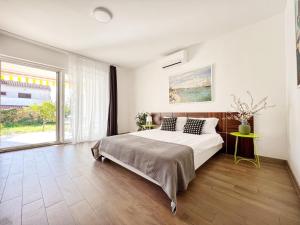 a bedroom with a large bed and a large window at Apartments Teodora Maria in Novigrad Istria