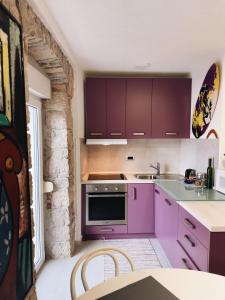 eine Küche mit lila Schränken und einer Arbeitsplatte in der Unterkunft Apartment Picasso Selce in Selce