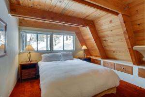 een slaapkamer met een wit bed in een kamer met houten plafonds bij Rustic Truckee Cabin with Donner Lake Views! in Truckee