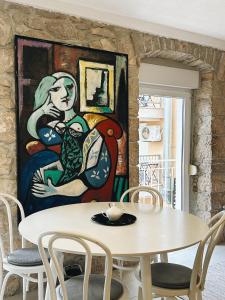 ein Esszimmer mit einem Tisch und einem Gemälde an der Wand in der Unterkunft Apartment Picasso Selce in Selce