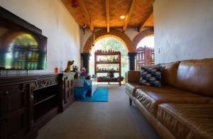 - un salon avec un canapé en cuir brun dans l'établissement Preciosa casa La Tolina en Puebla, à Santa María Tonantzintla