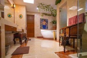 La salle de bains est pourvue d'une baignoire, d'une table et d'un lavabo. dans l'établissement Preciosa casa La Tolina en Puebla, à Santa María Tonantzintla
