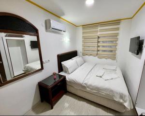 a small bedroom with a bed and a mirror at TAG Pansiyon in Antalya