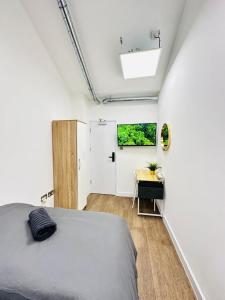 a bedroom with a bed and a white wall at The Grand M London city in London