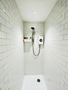 a white tiled bathroom with a shower stall at The Grand M London city in London