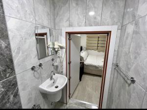 a bathroom with a sink and a mirror and a bed at TAG Pansiyon in Antalya