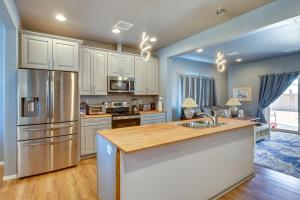 a kitchen with white cabinets and a stainless steel refrigerator at Pet-Friendly Kingman Vacation Rental Near Route 66 in Kingman