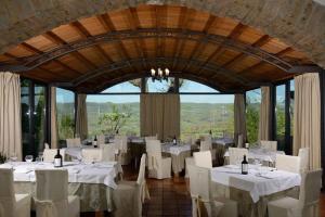 a dining room with white tables and white chairs at Agriturismo Campo Antico in Orte