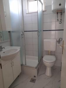 a bathroom with a shower and a toilet and a sink at Villa-kuća za odmor "RATAC" in Bol