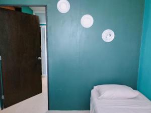 Habitación con cama y pared azul en Relax Home Aeropuerto-Tren Maya, en Chetumal