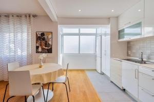 a kitchen and dining room with a table and chairs at Charroque in Setúbal