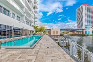 - une piscine dans un bâtiment situé à côté d'une étendue d'eau dans l'établissement HYDE BEACH HOUSE #2408 THREE-BEDROOM, WATERFRONT, OCEAN AND INTERCOSTAL VIEW, ROOFTOP POOL, 5 MiN WALK TO BEACH, à Hollywood