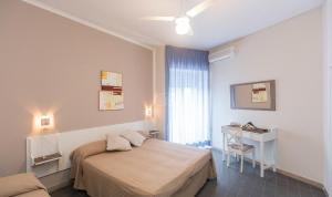a bedroom with a bed and a desk and a window at Hotel Anna in Terracina +72 photos