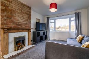 a living room with a fireplace and a couch at Gedling Contractors Delight! in Nottingham