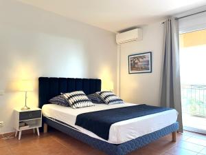 - une chambre avec un lit doté d'une tête de lit bleue et d'une fenêtre dans l'établissement Villa Romuald, à Sainte-Maxime 24 autres photos