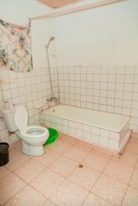 uma casa de banho com um WC, uma banheira e um lavatório. em Auberge La Caverne em Kigali