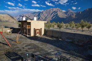 a house in the middle of a desert with mountains at Baltistan Fort in Skardu