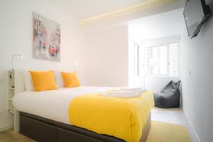 1 dormitorio con 1 cama con manta amarilla en The Plaza Flat, en Lisboa