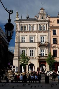 grupa ludzi siedzących na ławce przed budynkiem w obiekcie The Bonerowski Palace Boutique Hotel w Krakowie
