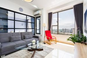 a living room with a couch and a glass table at TeeUp Home - Infinity Pool Signature in Ho Chi Minh City