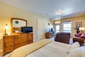 a bedroom with a bed and a dresser with a television at Cozy Birchwood Condo on Tagalong Golf Course! in Birchwood