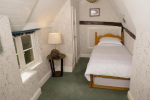 a small bedroom with a bed and a window at The Sun Hotel in Canterbury +2 photos
